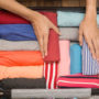 mulher organizando roupas em mala