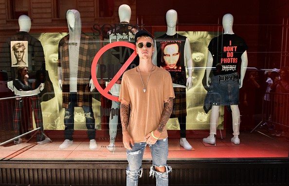 Justin Bieber em frente a vittrine de uma loja