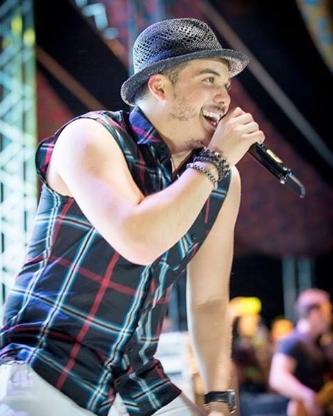 Wesley Safadão cantando com blusa xadrez