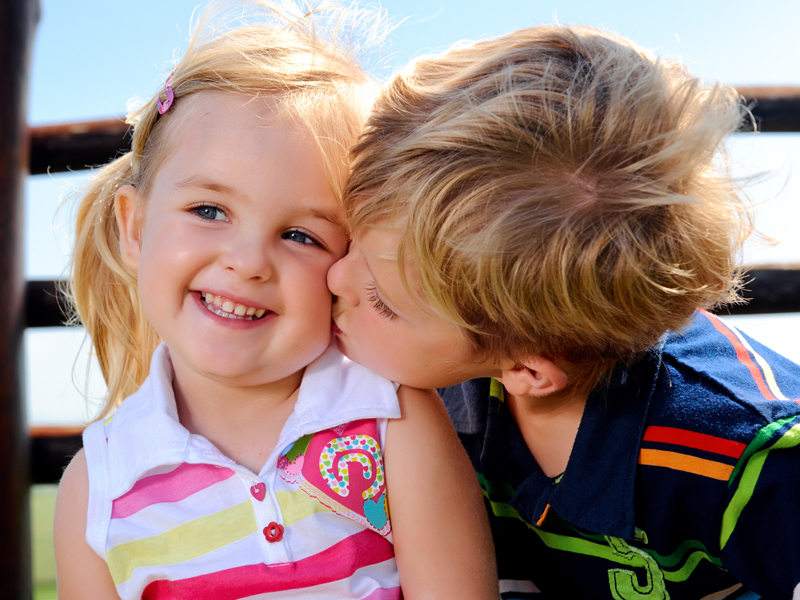 Menininho beijando meninha