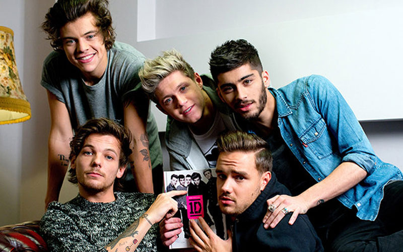 one direction com zayn segurando um livro