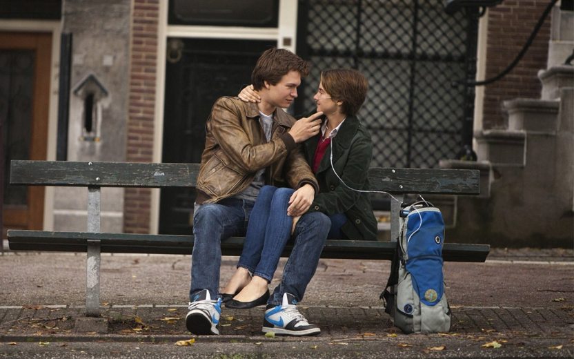 A Culpa é das Estrelas: Hazel e Gus em um banco de parque olhando um para o outro