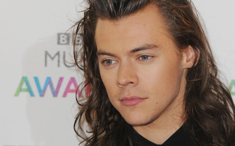 Harry Styles com cabelo comprido em evento com One Direction