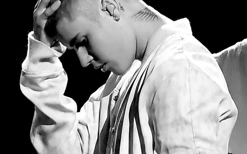 justin bieber em show com a mão na cabeça