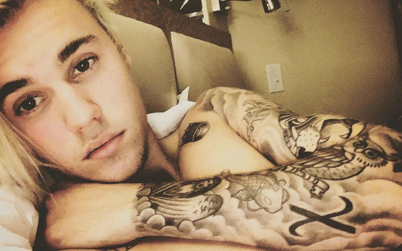 justin bieber mostrando suas tatuagens