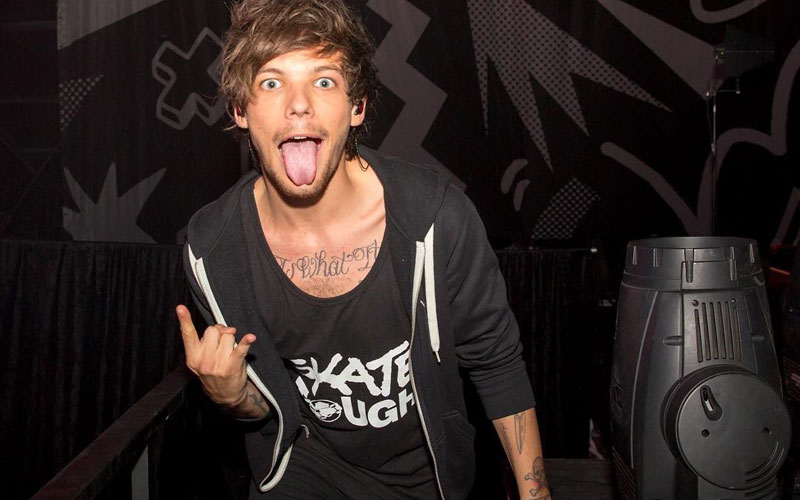 louis tomlinson cantando com cara de rock n roll