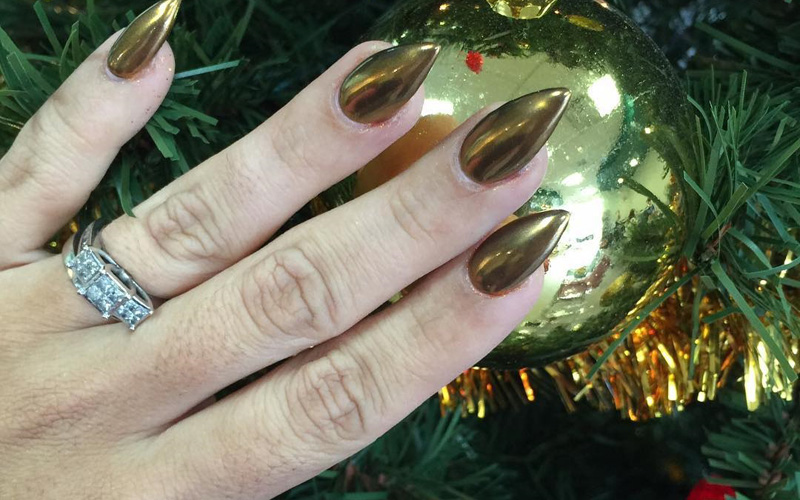 unhas cromadas douradas e uma árvore de natal