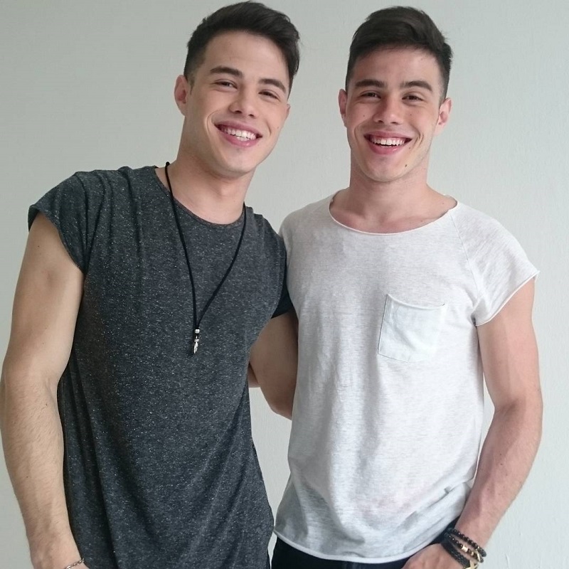 Irmãos Rocha sorrindo, de camiseta cinza e branca