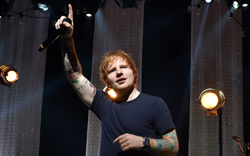 ed sheeran com as mãos pra cima cantando