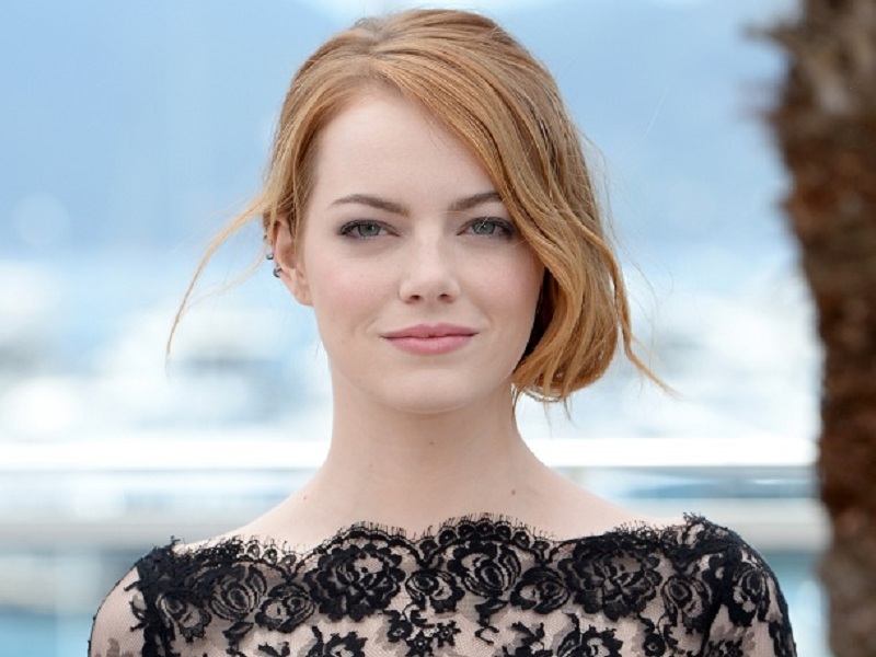 Emma Stone de cabelo preso e vestido preto