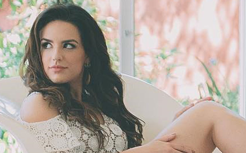kéfera sentada em uma cadeira com vestido branco