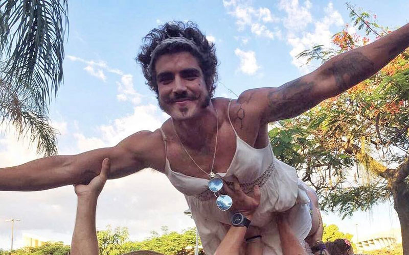 Caio Castro sendo carregado por amigos de vestido