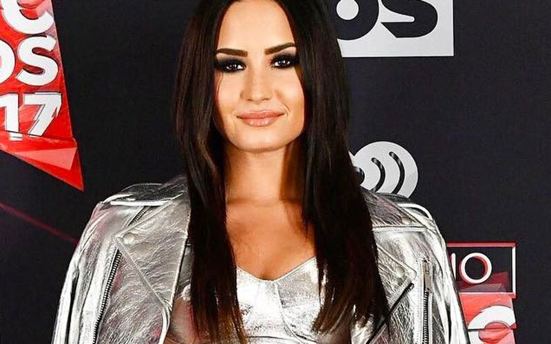 Demi Lovato com cabelo liso e jaqueta prateada