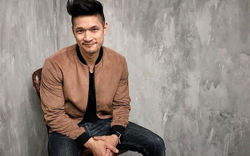 Harry Shum Jr. com casaco marrom