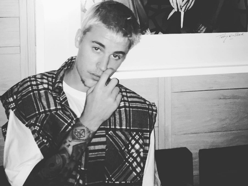 Justin Bieber com a mãe no rosto em foto preta e branca