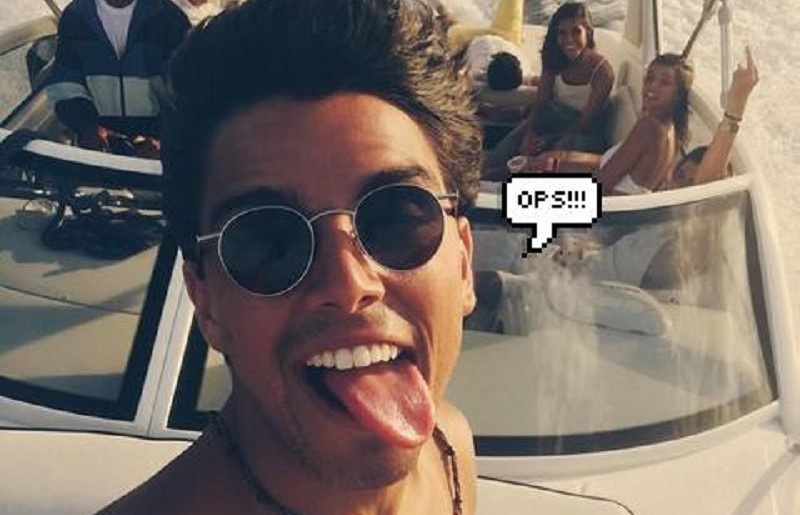 Rodrigo Simas fazendo selfie em barco, de óculos de sol e mostrando a língua