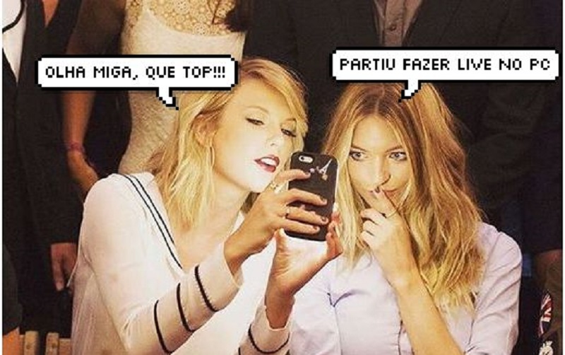 Taylor Swift mostrando algo no celular para uma amiga, que faz cara de interesse