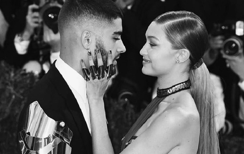 Zayn e Gigi Hadid, um de frente para o outro, ela com a mão no rosto dele