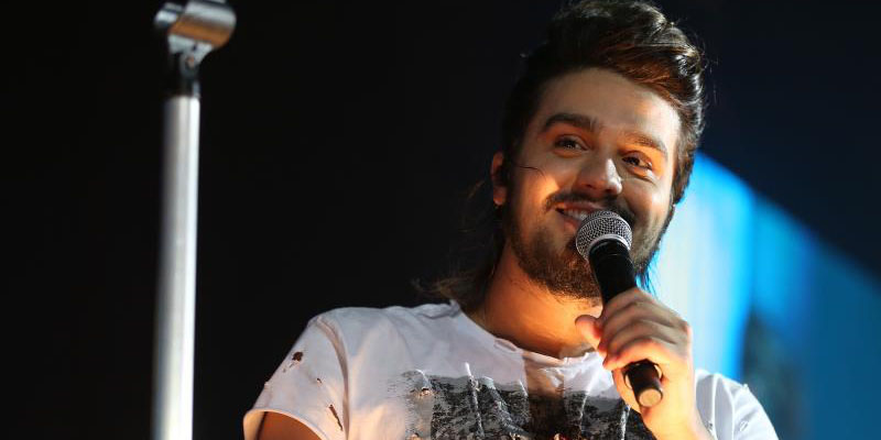 uma imagem com a foto do cantor Luan Santana cantando