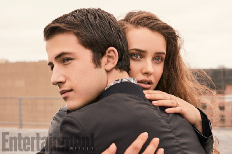 Katherine Langford abraçando Dylan Minnette, que usa jaqueta preta