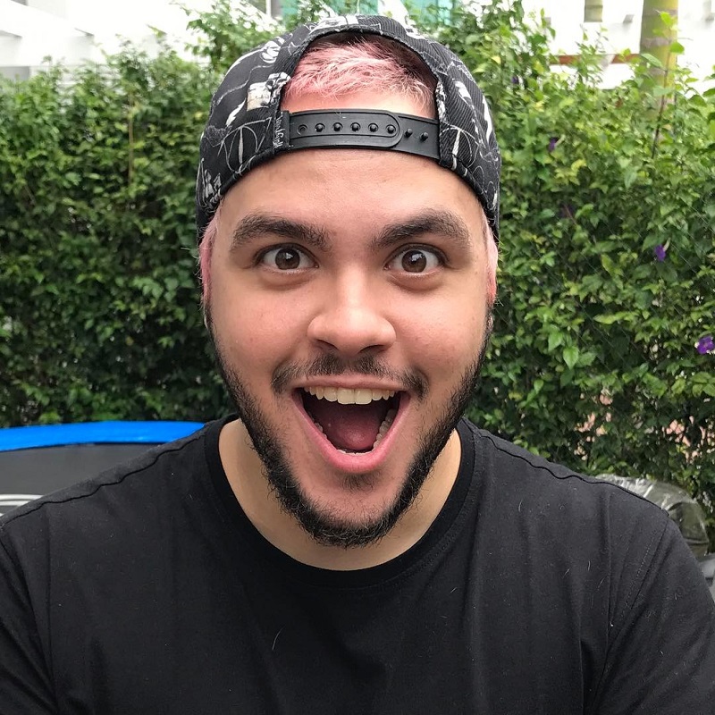 Luccas Neto com cara de surpresa, usando boné