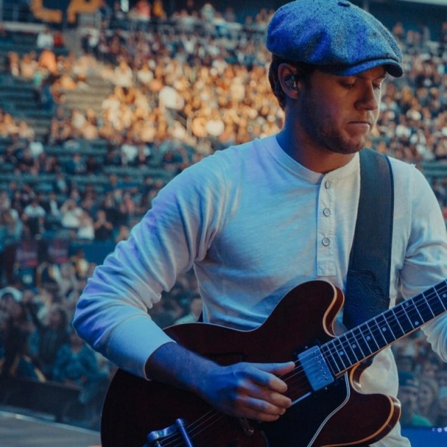 Nial Horan de boina tocando em show