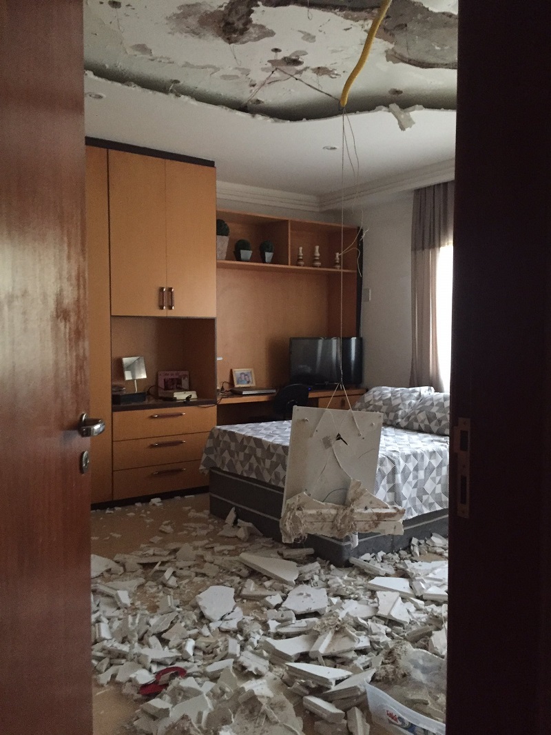 foto mostra quarto com teto todo destruído e destroços no chão