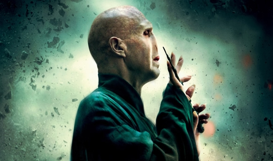 Voldemort, vilão de Harry Potter, segurando varinha, em fundo verde