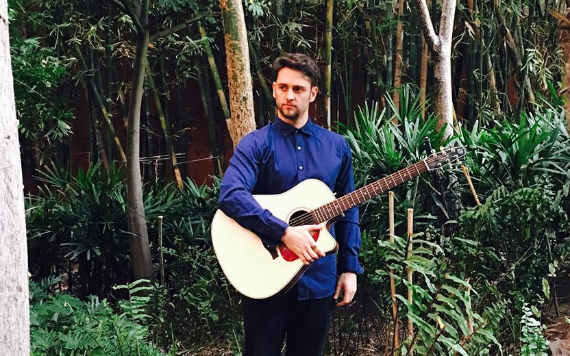 christofer segura violão em meio a jardim