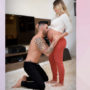 Gusttavo Lima ajoelhado, sem camisa, beija marriga de Andressa, que está em pé usando bluca que deixa barriga a mostra