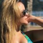Larissa Manoela de biquíni verde e com as mãos no cabelo