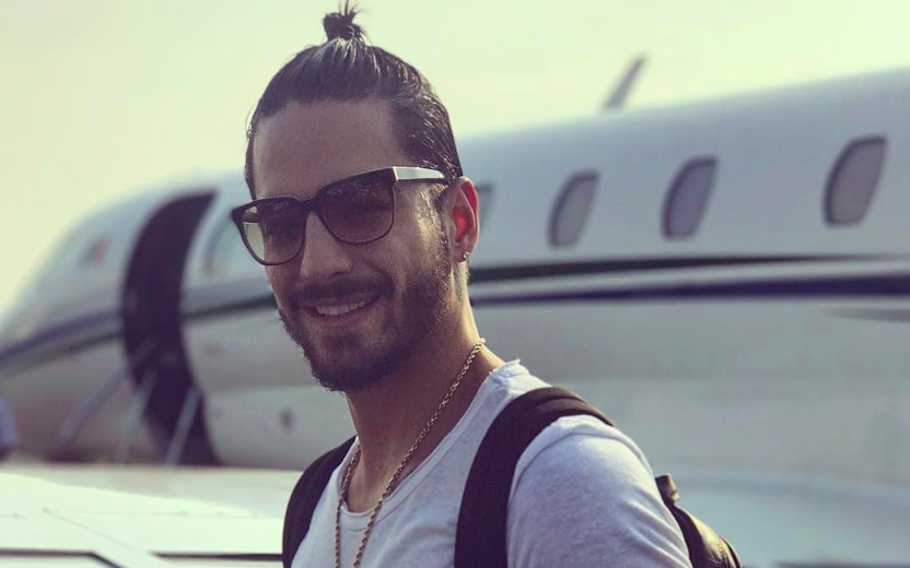 Maluma posa para foto em frente a um avião
