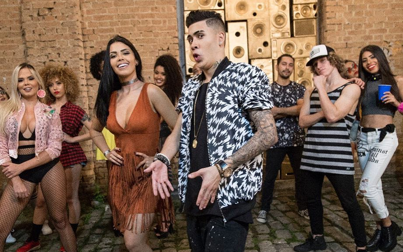 kevinho fazendo sarrada junto a bailarinas durante gravação de clipe