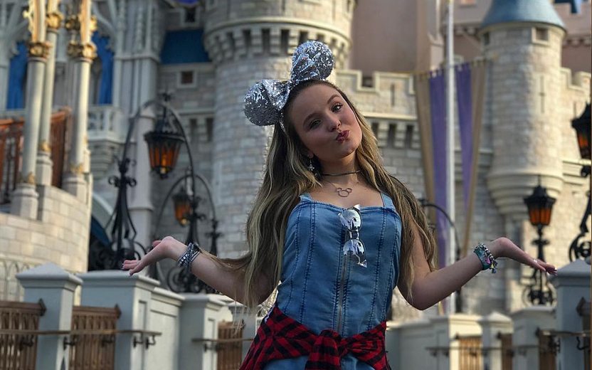 Larissa Manoela usa orelhas de mickey prateadas e posa em frente à castelo da Disney