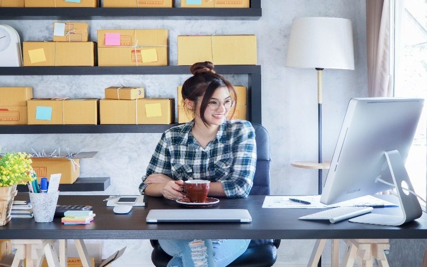 Garota sentada em uma mesa olhando para o computador