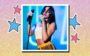 Dua Lipa de top branco segurando o microfone