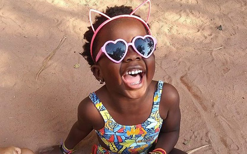 Titi sorrindo e usando óculos de sol