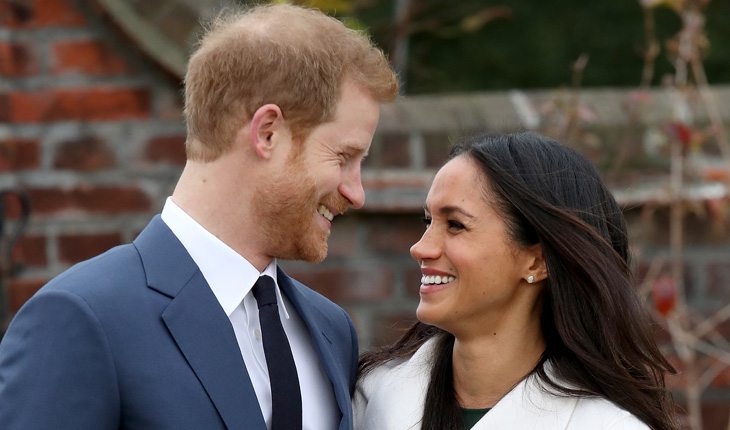 Príncipe Harry e Meghan Markle sorrindo um para o outro