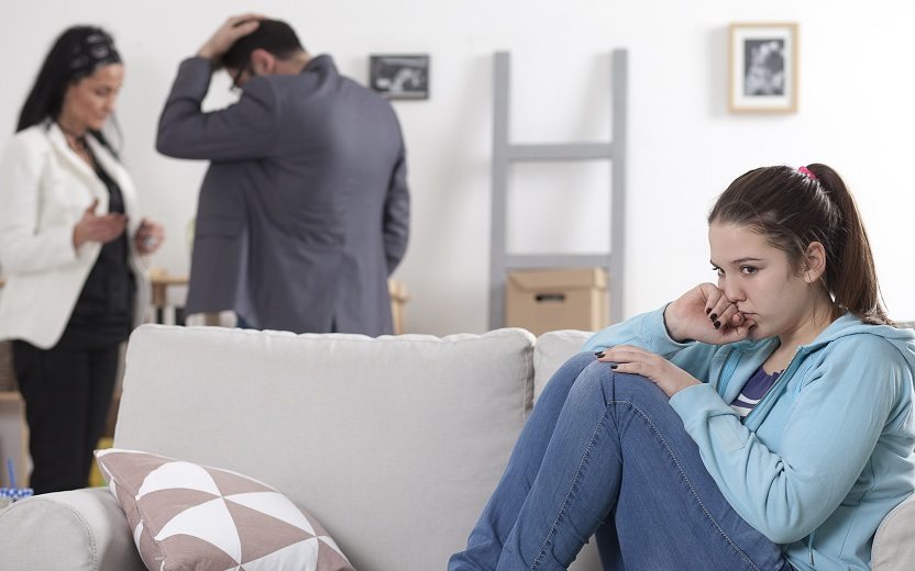 Menina triste com os pais separados brigando