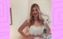 Niina Secrets com vestido de noiva e mãos na cintura